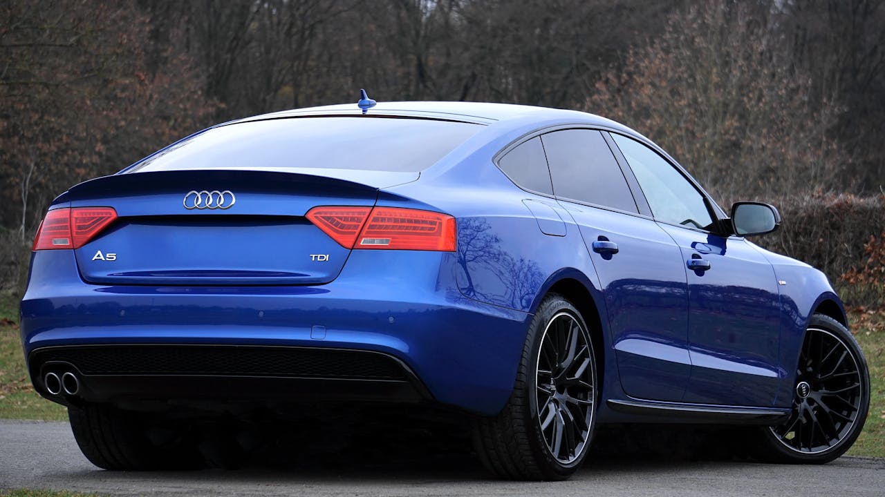 A stylish blue Audi A5 photographed in a peaceful outdoor environment, showcasing modern design and luxury.